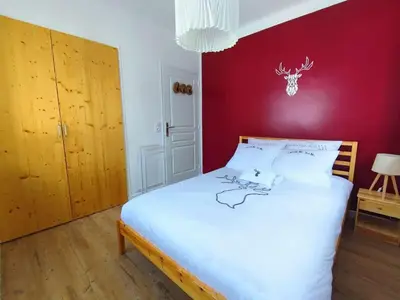 a bedroom with a white bed with a red wall at Le Chamois d'Assy, résidence alpine de charme in Passy