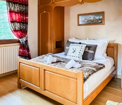 a bedroom with a bed with a wooden frame at Chalet Orchidee Megeve sur les pistes in Megève