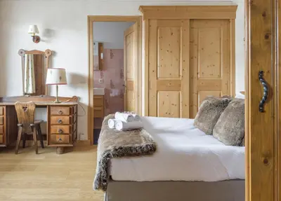 a bedroom with a bed with a dresser and a desk at Chalet Orchidee Megeve sur les pistes in Megève