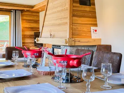 a table with red bowls and plates and glasses on it at Chalet Orchidee Megeve sur les pistes in Megève