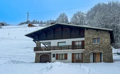 a house in the snow with snow at Chalet Orchidee Megeve sur les pistes in Megève