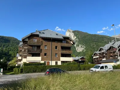 two cars parked in front of a large building at Samoens centre - appartement une chambre in Samoëns