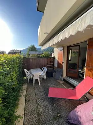 a patio with a table and chairs next to a building at Samoens centre - appartement une chambre in Samoëns