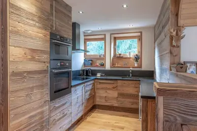 a kitchen with wooden walls and wooden counters at Très bel appartement Duplex 9 couchages in Megève