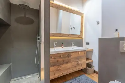a bathroom with a sink and a shower with a mirror at Très bel appartement Duplex 9 couchages in Megève