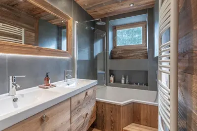 a bathroom with a tub and a sink and a bath tub at Très bel appartement Duplex 9 couchages in Megève
