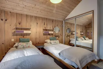 two beds in a room with wooden walls at Large peaceful chalet for mountain adventures! Perfect for Flégère and Grand Montet skiing in Chamonix-Mont-Blanc