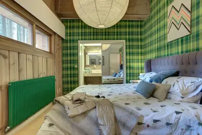 a bedroom with a large bed and a mirror at Large peaceful chalet for mountain adventures! Perfect for Flégère and Grand Montet skiing in Chamonix-Mont-Blanc