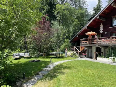 a woman standing in front of a house at Large peaceful chalet for mountain adventures! Perfect for Flégère and Grand Montet skiing in Chamonix-Mont-Blanc