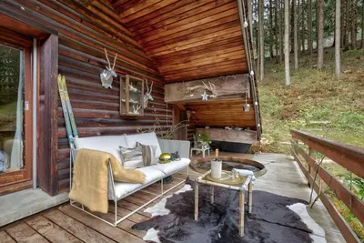 a porch of a wooden cabin with a couch and a table at Large peaceful chalet for mountain adventures! Perfect for Flégère and Grand Montet skiing in Chamonix-Mont-Blanc