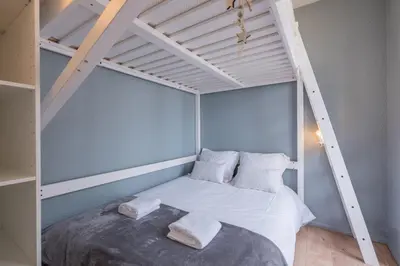 a bed in a room with a loft bed at Charming flat right in the city centre in Chamonix-Mont-Blanc