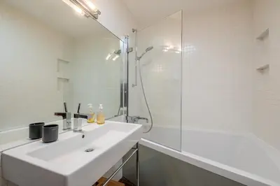 a white bathroom with a sink and a shower at SmartStay Loft - Exterieur et vue Mont Blanc in Chamonix-Mont-Blanc