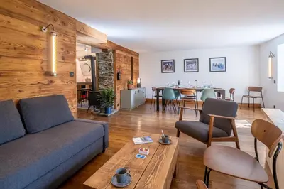 a living room with a couch and a table at SmartStay Loft - Exterieur et vue Mont Blanc in Chamonix-Mont-Blanc