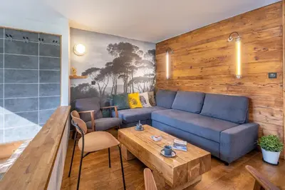 a living room with a blue couch and a table at SmartStay Loft - Exterieur et vue Mont Blanc in Chamonix-Mont-Blanc
