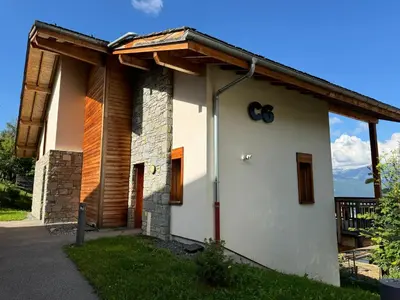 a white house with a wooden roof at Chalet Petit Val in Combloux