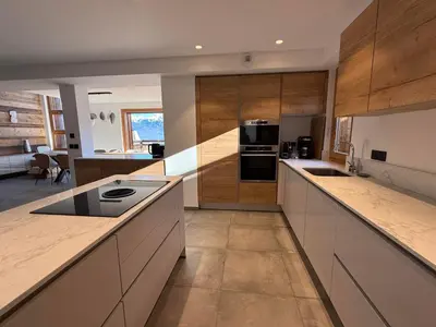 a large kitchen with white counters and wooden cabinets at Chalet Petit Val in Combloux