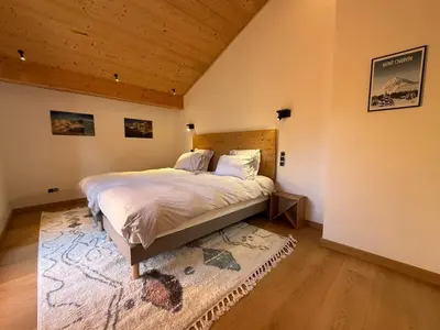 a bedroom with a bed and a wooden ceiling at Chalet Petit Val in Combloux
