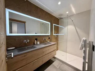 a bathroom with a sink and a glass shower at Chalet Petit Val in Combloux