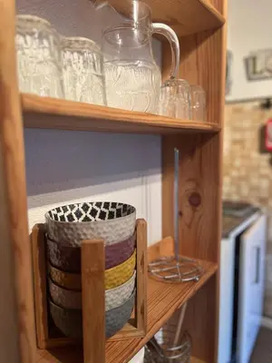 a shelf with a stack of bowls and plates at Emeraude, petit cocon proche des pistes in Saint-Gervais-les-Bains