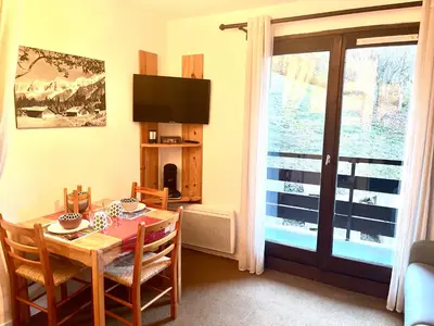 a dining room with a table and a window at Emeraude, petit cocon proche des pistes in Saint-Gervais-les-Bains