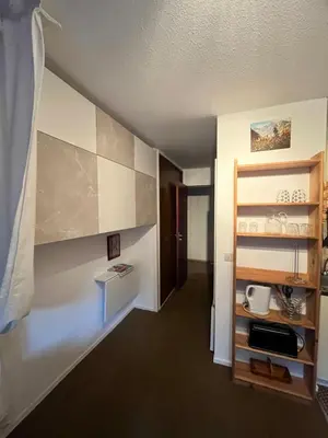 a room with a hallway with a kitchen with a shelf at Emeraude, petit cocon proche des pistes in Saint-Gervais-les-Bains