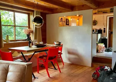 a kitchen with a table and red chairs in a room at Hameau de la Côte in Les Houches
