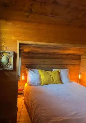 a bedroom with a bed with a wooden wall at Hameau de la Côte in Les Houches