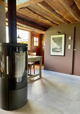 a living room with a table and a stove at Hameau de la Côte in Les Houches