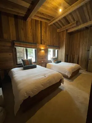 two beds in a room with wooden walls at La Belle Etoile in Saint-Gervais-les-Bains