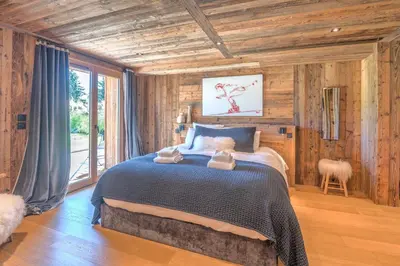 a bedroom with a bed in a room with wooden walls at Appartement Horizon Panoramique - Welkeys in Combloux