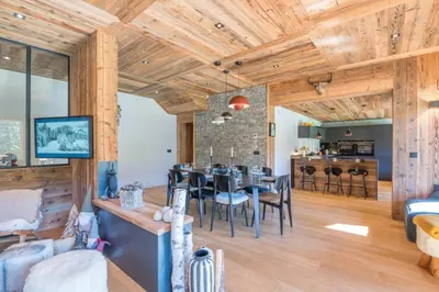 a dining room and living room with wooden ceilings at Appartement Horizon Panoramique - Welkeys in Combloux