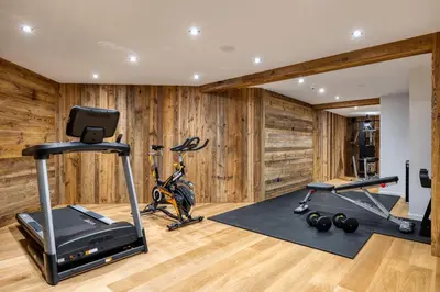 a gym with wood paneling and a room with exercise equipment at Appartement Horizon Panoramique - Welkeys in Combloux