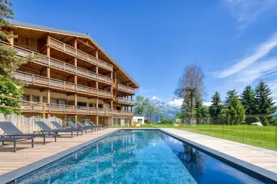 a swimming pool in front of a building at Appartement Horizon Panoramique - Welkeys in Combloux