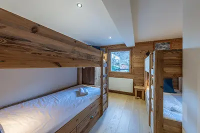 a bedroom with two bunk beds in a cabin at Le Chalet 138 Megève séjour pour 8 confort espace charme calme in Demi-Quartier