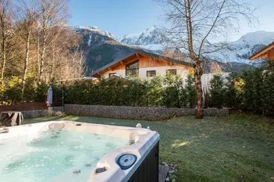 a hot tub in a yard with a house at Chalet Arve - Alpes Travel - Chamonix - Sleeps 10 in Chamonix-Mont-Blanc