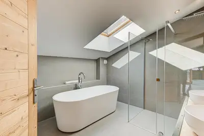a bathroom with a white tub and a skylight at Chalet Arve - Alpes Travel - Chamonix - Sleeps 10 in Chamonix-Mont-Blanc