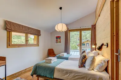 a bedroom with a bed and a large window at Chalet Arve - Alpes Travel - Chamonix - Sleeps 10 in Chamonix-Mont-Blanc