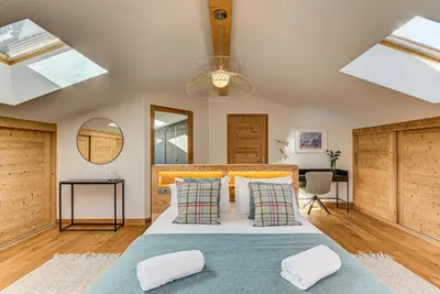 a bedroom with a large bed with pillows at Chalet Arve - Alpes Travel - Chamonix - Sleeps 10 in Chamonix-Mont-Blanc