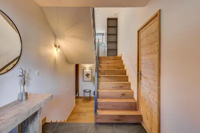 a staircase in a house with a wooden door at Chalet Arve - Alpes Travel - Chamonix - Sleeps 10 in Chamonix-Mont-Blanc