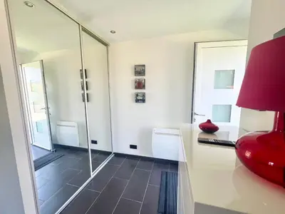 a bathroom with a glass shower and a red chair at Charmant appartements Sallanches in Sallanches
