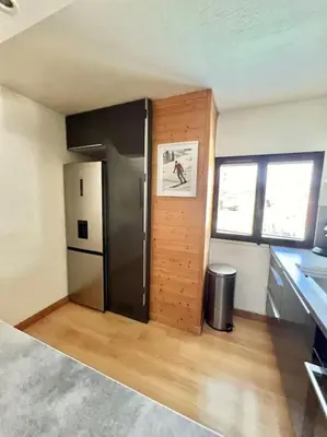 a kitchen with a black refrigerator in a room at Charmant appartements Sallanches in Sallanches