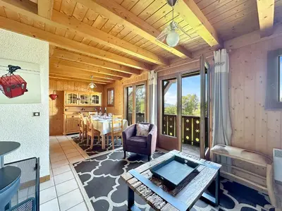 a living room with a table and a dining room at CH143 - Chalet cosy 6 personnes in Les Carroz d'Araches