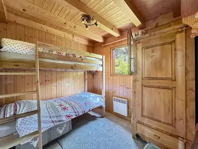 a bedroom with bunk beds in a wooden cabin at CH143 - Chalet cosy 6 personnes in Les Carroz d'Araches