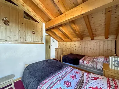 a bedroom with two beds in a wooden cabin at CH143 - Chalet cosy 6 personnes in Les Carroz d'Araches