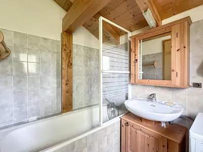 a bathroom with a sink and a mirror and a tub at CH143 - Chalet cosy 6 personnes in Les Carroz d'Araches