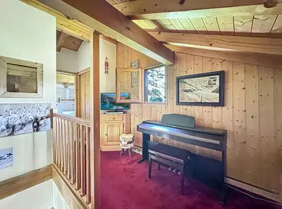 a living room with a piano in a house at CH143 - Chalet cosy 6 personnes in Les Carroz d'Araches