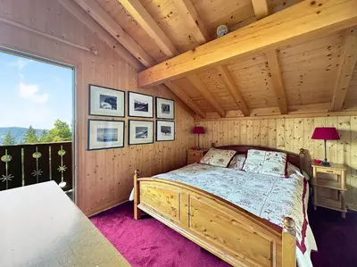 a bedroom with a bed in a wooden room at CH143 - Chalet cosy 6 personnes in Les Carroz d'Araches