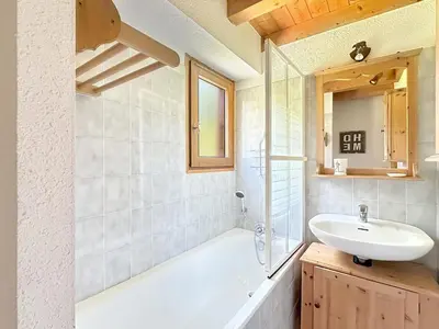 a bathroom with a sink and a tub and a mirror at CH143 - Chalet cosy 6 personnes in Les Carroz d'Araches