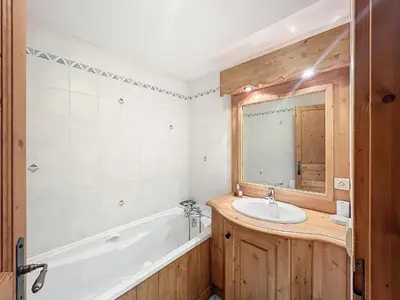 a bathroom with a tub and a sink and a mirror at Chalet individuel avec garage, terrasse, buanderie et cuisine équipée - FR-1-560-149 in Sallanches