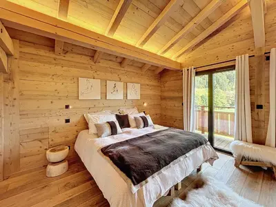 a bedroom with a large bed in a wooden room at Chalet de luxe avec vue Mont Blanc et parking - FR-1-560-150 in Sallanches